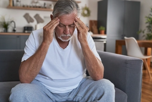 Мужчина с амнезией держится за голову