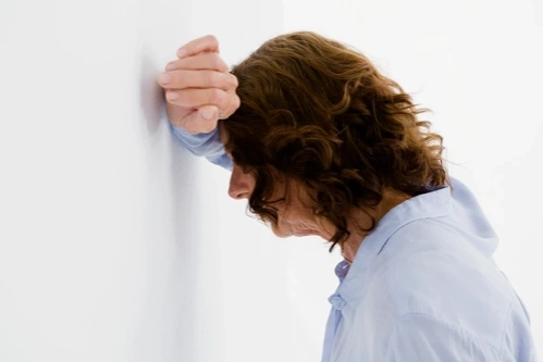 женщина с тревожным расстройством облокотилась на стену