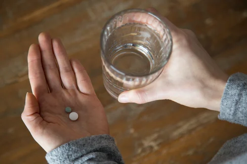 женщина принимает таблетки при алкогольном отравлении