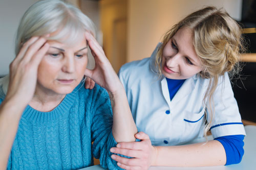 Медработник и женщина с расстройством памяти сидят за столом