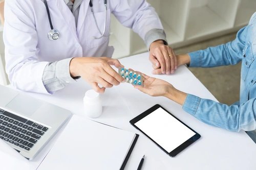 доктор дает пациентке таблетки для лечения синдрома Ганзера