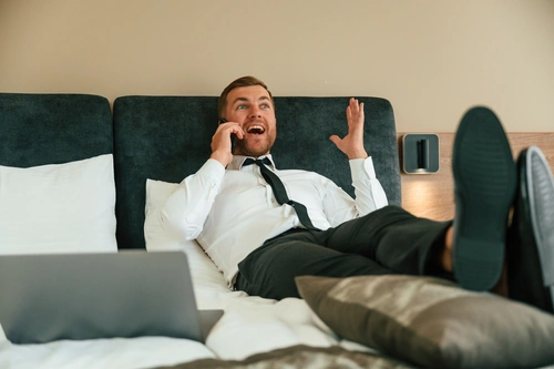 мужчина с гипоманией лежит на кровати с телефоном