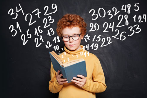 Мальчик с признаками синдрома саванта смотрит книгу по математике