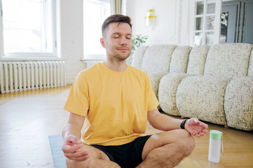 Мужчина с аэрофобией занимается медитацией в комнате