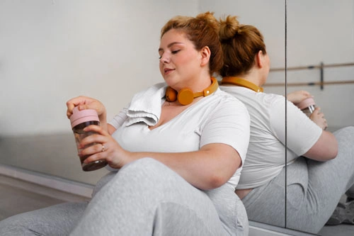 женщина с булимией сидит в танцевальном зале после тренировки