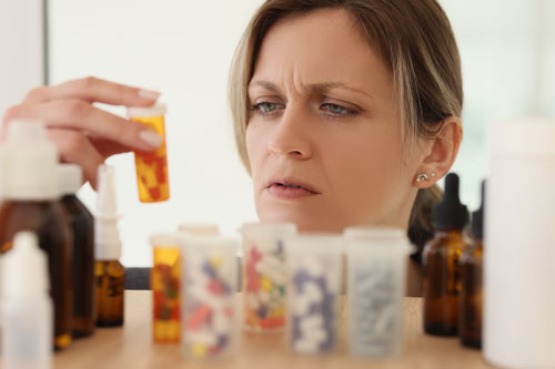 Женщина держит флакон с таблетками